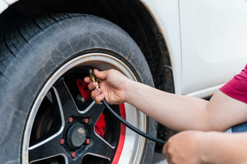 Close up of man filling air in the tires of his car. Hand and car wheel add air pressure.
